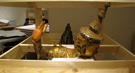 A male kinnara statue (Konbaung Period, 1752–1885) appears as though he is waving goodbye  before his custom crate is boxed up for shipment to the Asia Society in New York. (Photo credit: Pete Olson)