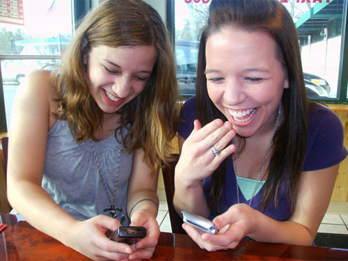 Teens texting and giggling